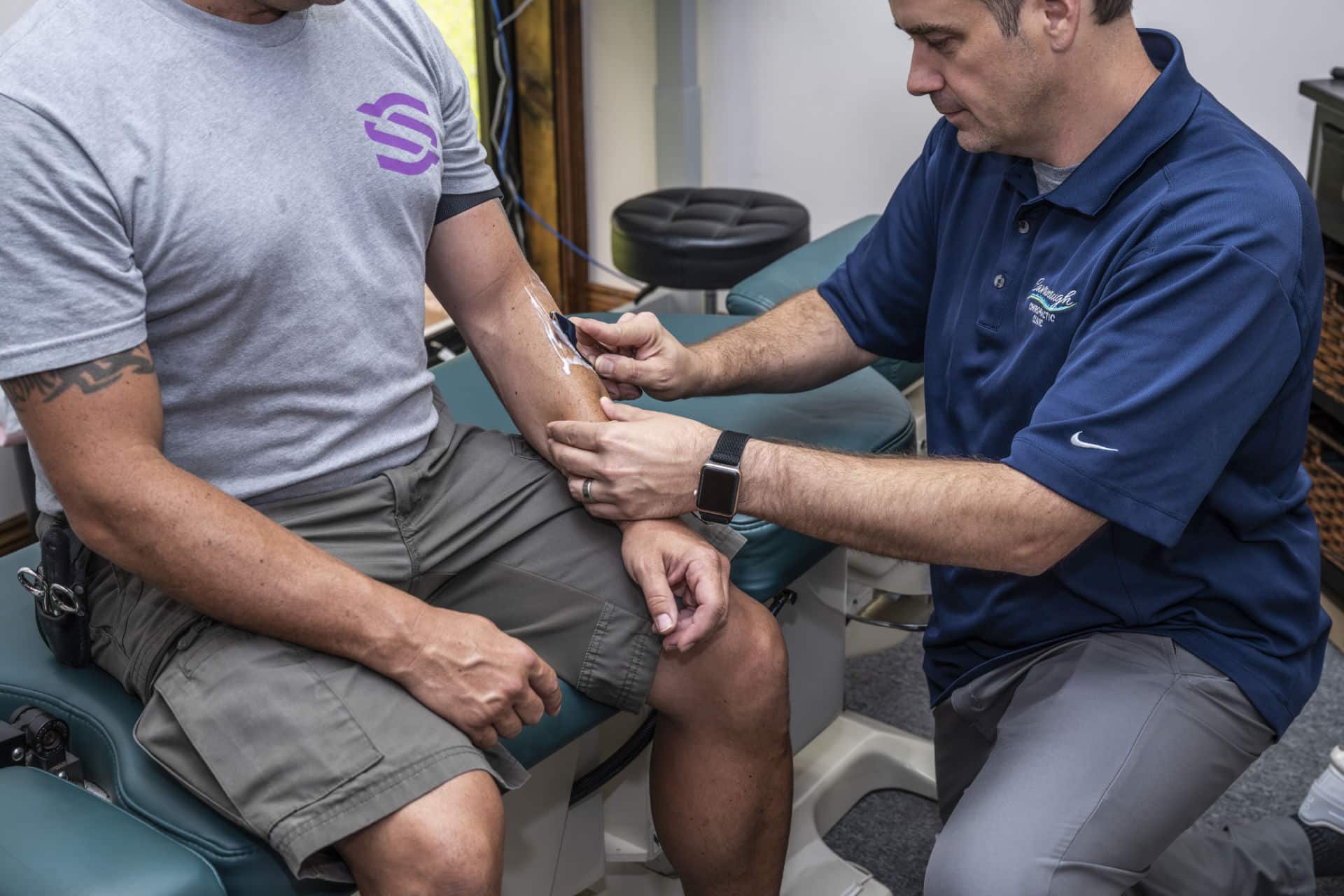 Chiropractor in Lafayette, LA performing Gua Sha therapy on a patient’s forearm