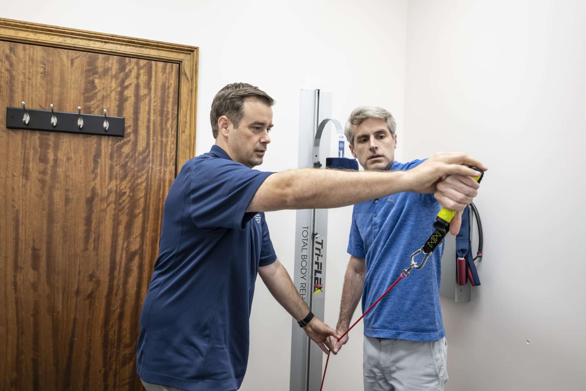 Chiropractor in Lafayette, LA guiding patient through therapeutic exercise for shoulder rehab