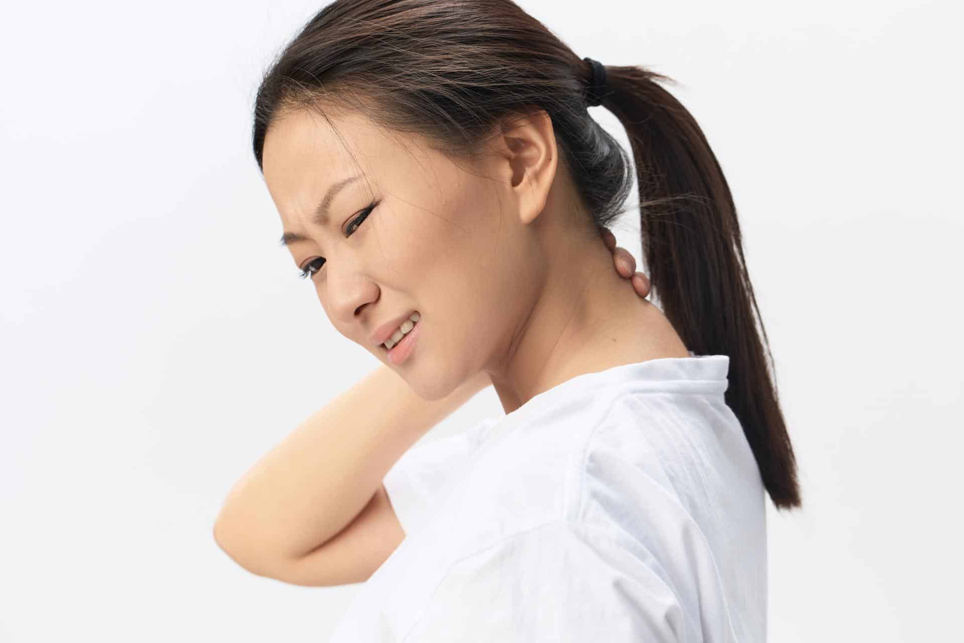 Woman holding neck in discomfort due to cervical hyperlordosis, seeking chiropractic care in Lafayette, Louisiana.