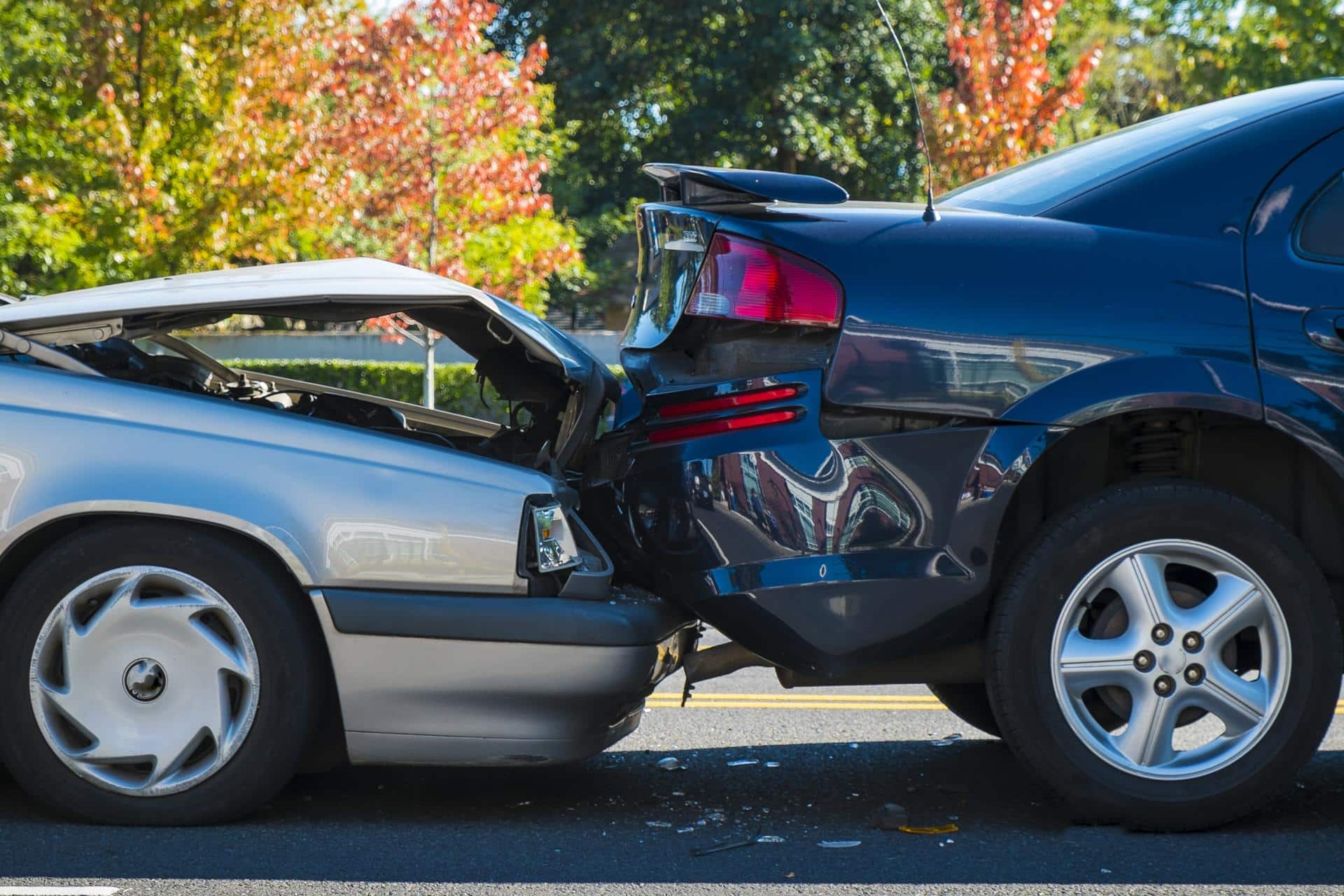 Two damaged cars after a rear-end collision on a sunny day, representing common auto accident injuries.