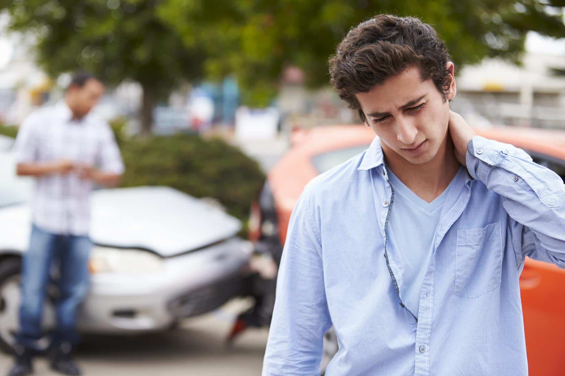Young man with neck pain after car accident, showing symptoms of cervical spine sprain in Lafayette, Louisiana