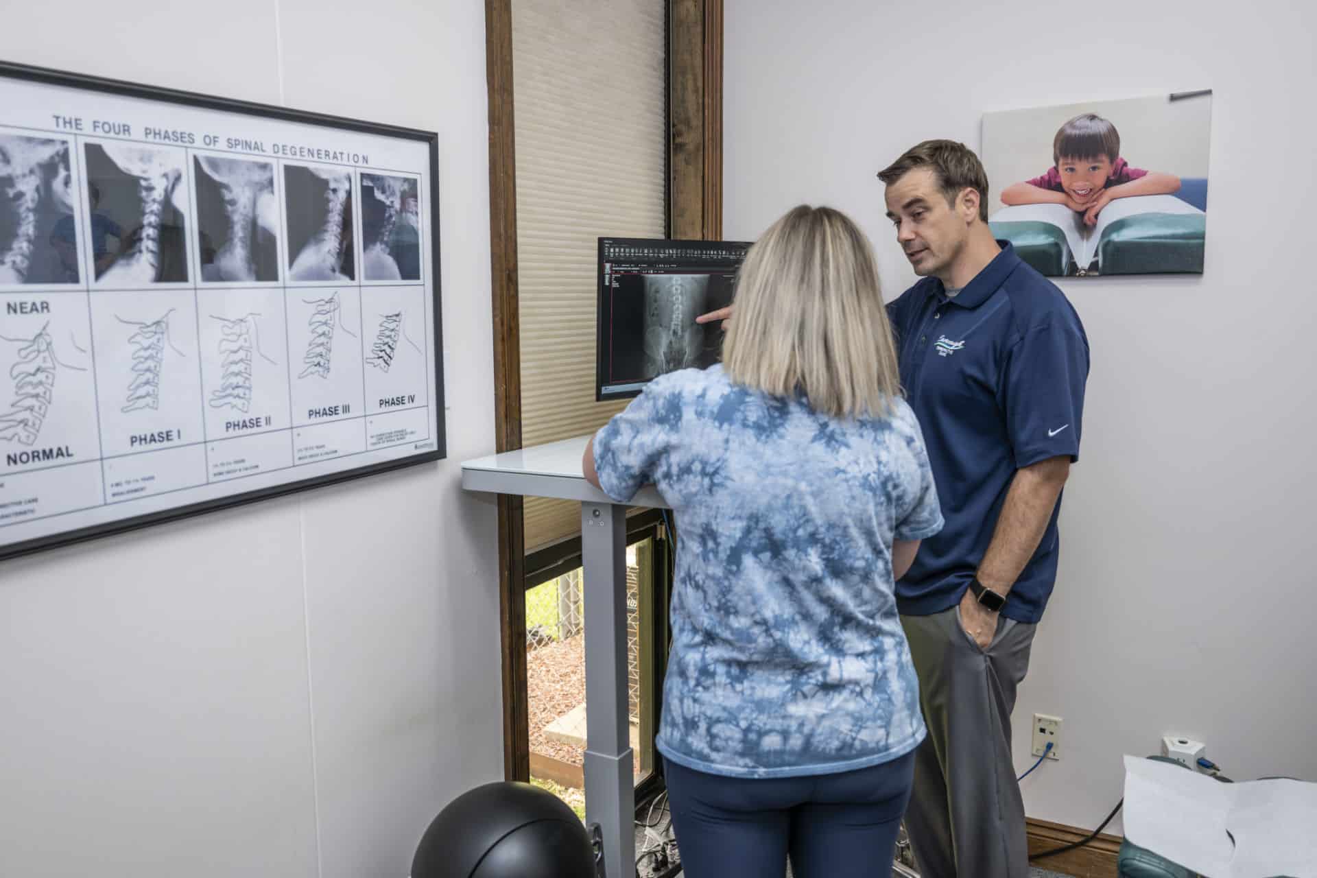 Chiropractor in Lafayette, LA reviewing spinal X-rays with a patient